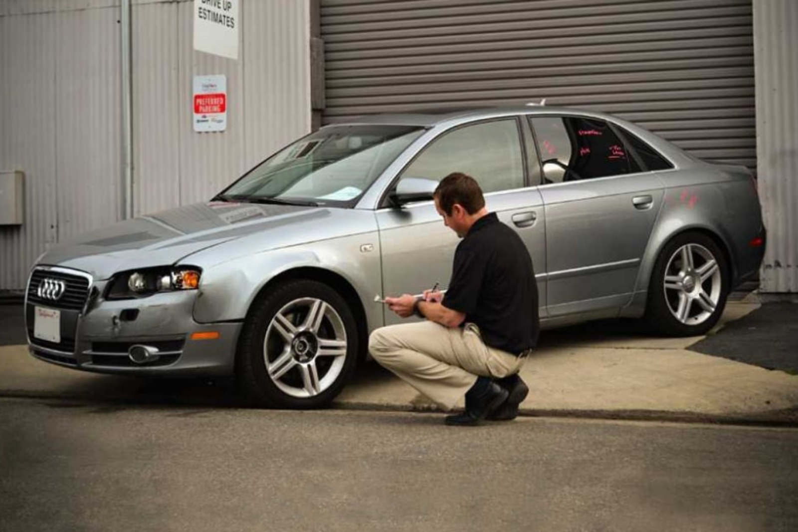 a man inspecting a vehicle for damage